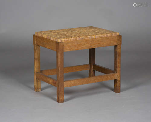 An early/mid-20th century Cotswold School oak framed stool, the woven rattan seat raised on