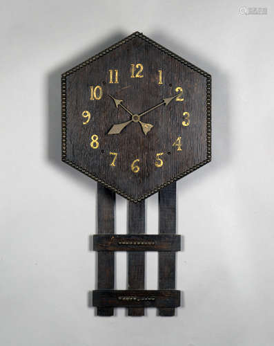 An Arts and Crafts oak wall clock with eight-day chiming movement, the hexagonal dial with applied