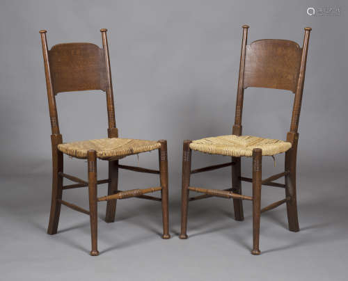 A set of six early 20th century Arts and Crafts oak and ash framed panel back dining chairs by