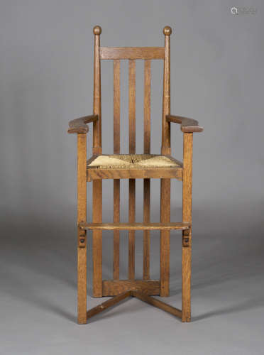 A late 19th/early 20th century Arts and Crafts oak framed child's high chair, in the manner of