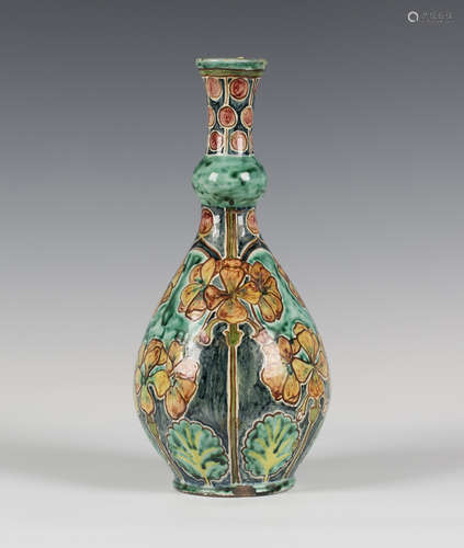 A Della Robbia Pottery bottle vase, circa 1900, painted with flowering stems of geranium against