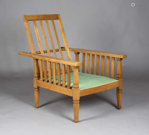 An Edwardian Arts and Crafts oak framed reclining armchair, in the manner of Shapland & Petter,