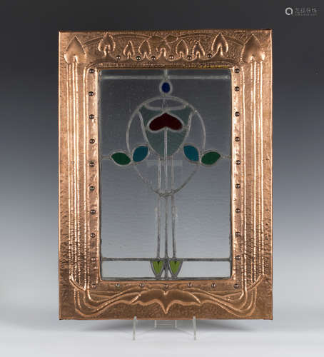 An Edwardian Arts and Crafts stained and leaded glass panel, mounted within a later hammered