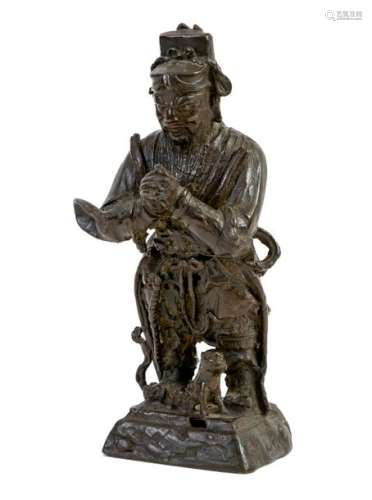 China, Ming period (1368-1644) Bronze templeguard depicted standing with a dog at his feetTraces of polychromyH: 24 cm(accidents)