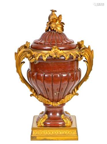 Large Louis XV style vase with two handles decorated with reeds and its lid in red marble from Verona carved with gadroons and gilt bronze and chiselled French work, 19thcentury period: 63 cm(restored at the foot)Provenance: Château de la Roquette (Hainaut)From a porphyry and gilt bronze vase made around 1750, probably coming from the collection of the Duke of Tallard that the Marquis de Marigny proposed to sell to the Crown in 1778. This vase decorated the salon of the First Consul in the Tuileries, it was still in this palace during the Second Empire.Bibliography: Pierre Verlet, Les bronzes dorés français du XVIIIè siècle, 1987, p. 62, ill. 58.