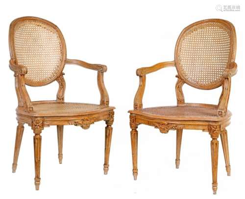 Pair of Louis XVI style caned cabriolets armchairs in carved and moulded natural wood, fluted and rudent feet. Medallionfile French work, late 18th century (customary restorations)