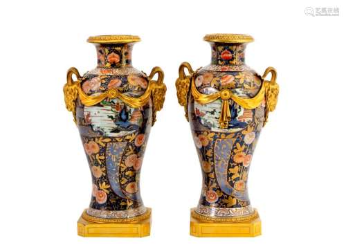 Pair of large baluster vases in polychrome Imari porcelain decorated with lake landscapes in cartouches on a floralbackground. Louis XVI style frame with two handles in the shape of a ram's head in chased and gilded bronze from the 19thCentury Epoch XVIIIthH: 47 cmProvenance: Château de la Roquette (Hainaut)(missing parts and restorations)A certificate of expertise signed by François d'Ansembourg on 27 March 2001 is attached.