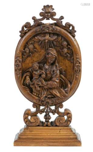 Virgin and Child surrounded by angels and the Holy Spirit in an oval cartouche Highrelief in carvedwalnut Late 17th-early 18thcentury H: 52 cm (excluding the rear base)Width: 29 cm(accidents and restorations)