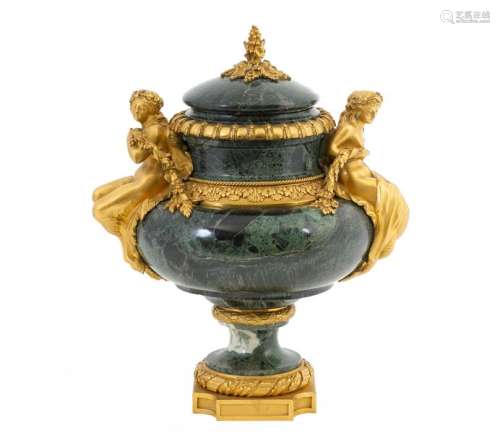 Louis XVI style vase and its lid in green Tinos marble with a rich chased and gilded bronze frame with two handles representing a mermaid and a satyr in the shape of a fruitFretel round hump Parisian work, mid 19thcentury (small accidents and restorations)H: 38 cmProvenance: Château de la Roquette (Hainaut) A certificate of expertise signed by François d'Ansembourg on December 8, 2005is attached.