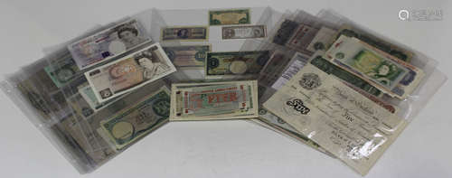 A collection of British and colonial banknotes, including a Bank of England white five pounds note