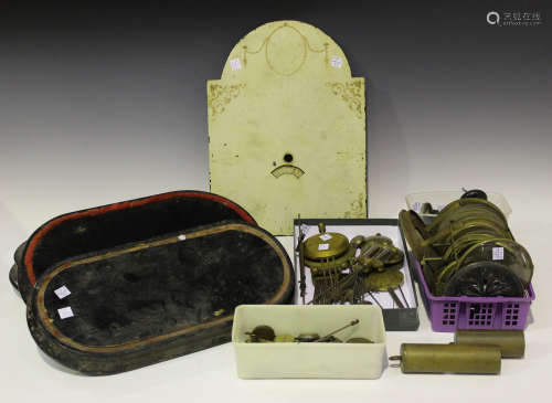 A collection of clock parts and accessories, including various pendulums, two weights, three