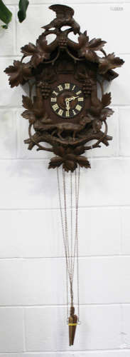 A late 19th/early 20th century Black Forest carved softwood cuckoo clock with weight driven movement