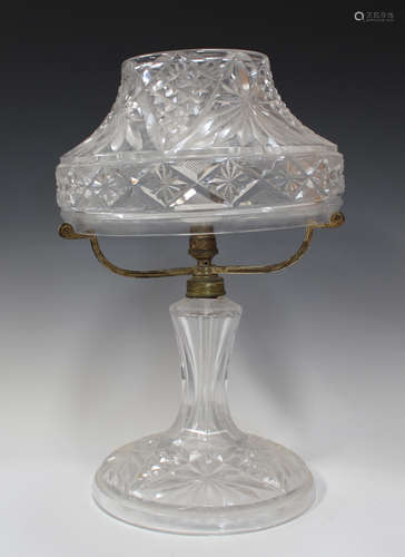 A cut glass table lamp, 20th century, the canopy shaped shade above a tapering stem and circular