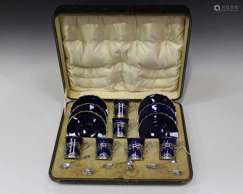 A set of six silver mounted Aynsley blue glazed and gilt rimmed bone china coffee cans and