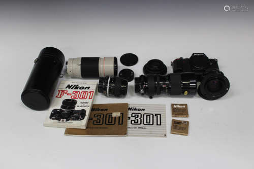A Nikon F-301 camera body with instruction manual and book, together with various accessories,
