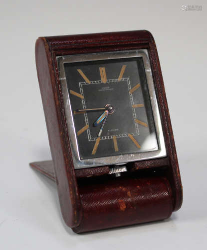 A Jaeger leather cased travelling bedside timepiece, the rectangular black dial with luminous