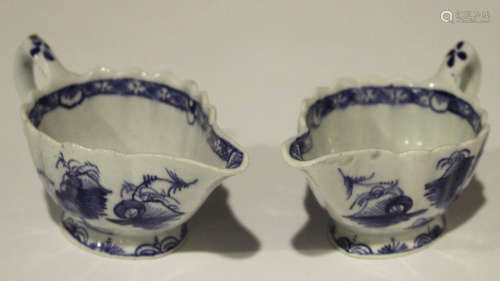 A pair of Bow porcelain creamboats, circa 1755-60, the fluted bodies painted in underglaze blue with