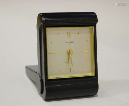 A black leather folding bedside alarm clock with eight day movement, the silvered rectangular dial