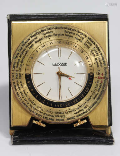 A Luxor gilt metal and leather cased travelling folding alarm clock, the signed dial with gilt baton