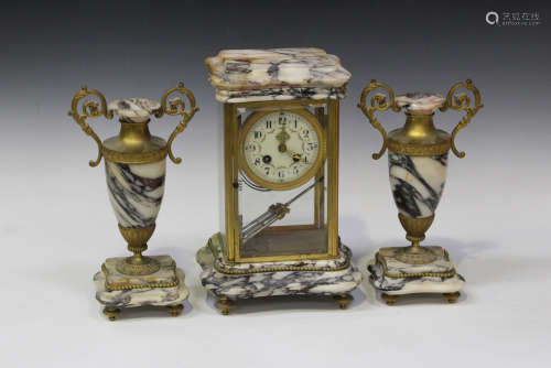 An early 20th century French marble and brass four glass mantel clock garniture, the clock with