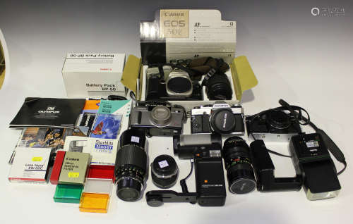 A collection of cameras and accessories, including Olympus OM10 and OM20 camera bodies, an OM-System