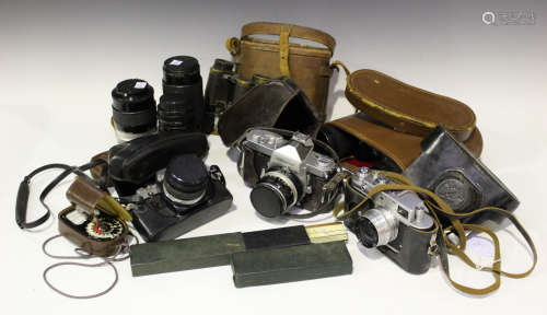 A collection of cameras and accessories, including a Nikon Nikkormat camera with Nikkor-H Auto 1:2