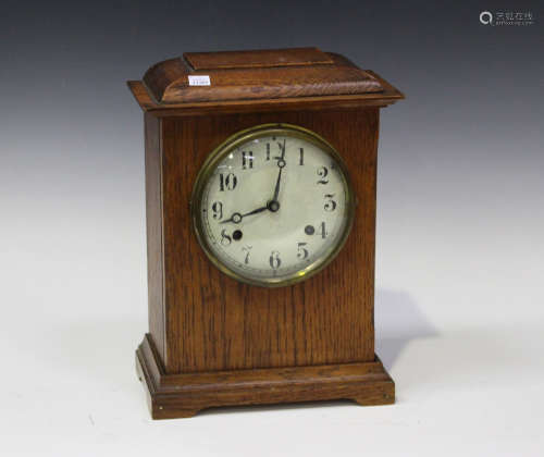 An early 20th century American oak cased mantel clock, striking on a gong, the case with moulded