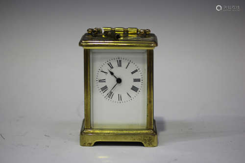 A 20th century French lacquered brass carriage timepiece, the glazed case with swing handle,