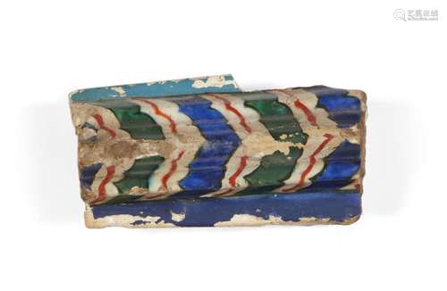 An Iznik border tile, Turkey, 16th century, of curved, ribbed, form, underglaze painted in cobalt