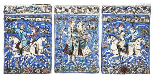 Three Qajar underglaze-painted moulded pottery tiles, Iran, 19th century, two depicting pairs of