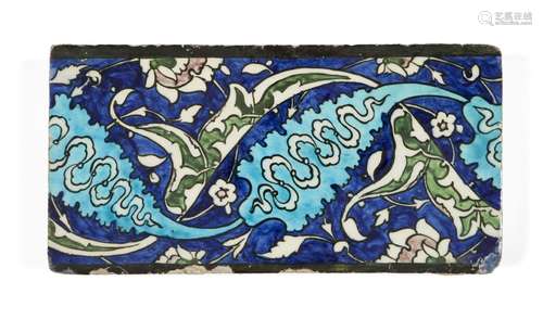 A Damascus Iznik border tile, late 16th century, of rectangular form, the cobalt-blue ground with