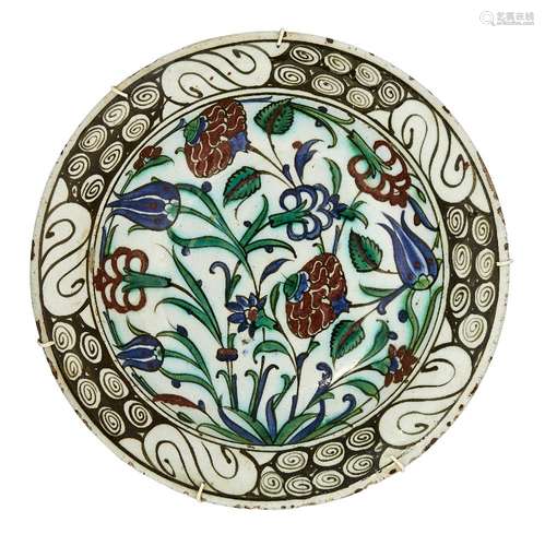 An Iznik pottery dish, Turkey, circa 1600, underglaze painted in raised red, cobalt blue, green