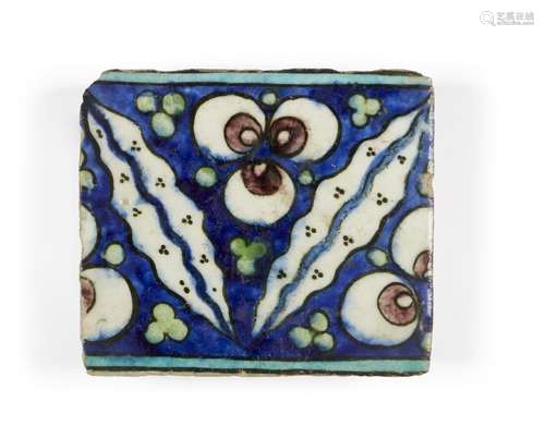 A Damascus Iznik border tile, 16th century, of rectangular form, the cobalt-blue ground decorated