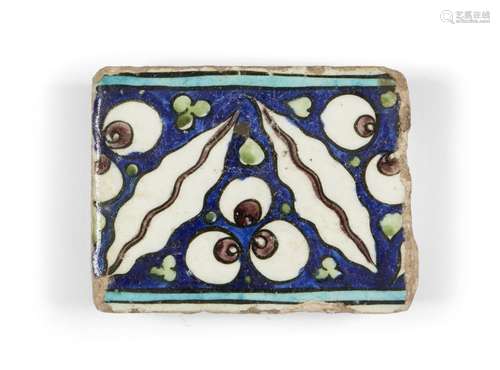 A Damascus Iznik border tile, 16th century, of rectangular form, the cobalt-blue ground decorated