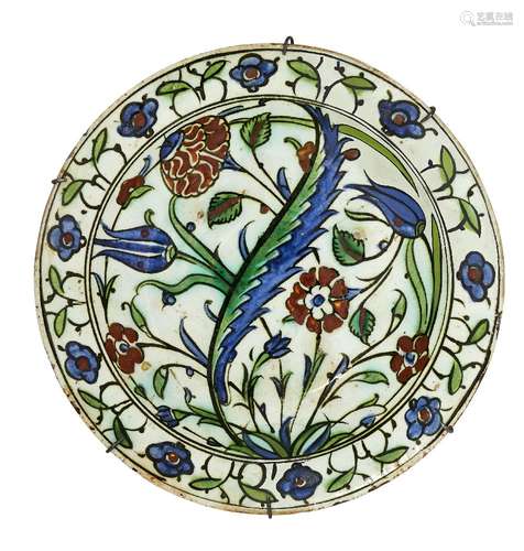 An Iznik pottery dish, Turkey, 17th century, of shallow rounded form on a short foot with everted