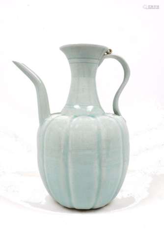 A Chinese yuan style celadon glazed ewer, with gently curving spout and reeded looping handle, the