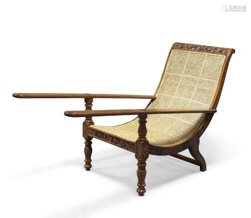 An Anglo Indian teak Planter's chair, 19th Century, with floral carved top rail above caned seat,