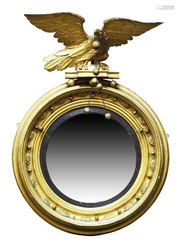 A Regency gilt framed circular wall mirror, the carved eagle crest with chain suspended ball