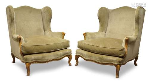 A pair of Louis XV style wingback armchairs, 20th Century, upholstered in green fabric with loose