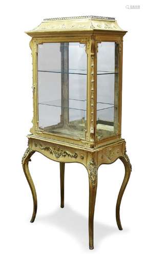 A French gilt metal mounted and silk vitrine, late 19th Century, the shaped cornice, above glazed