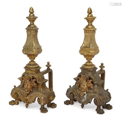 A pair of Louis XIV style andirons, 19th century, applied with a male mask to the front representing