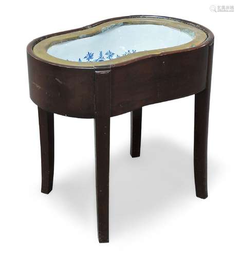 A mahogany bidet, 19th Century, the shaped top, with blue and white ceramic liner, reinforced with