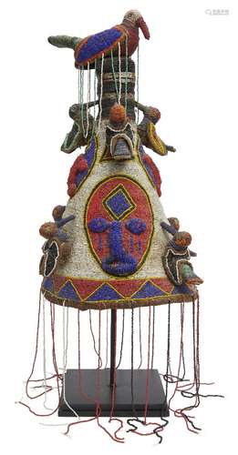 A Tribal headdress, Yoruba, Nigeria, of conical form with a bird finial at the top and bands of