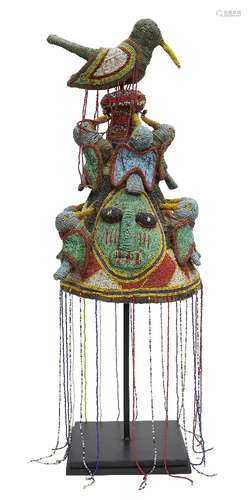 A Tribal headdress, Yoruba, Nigeria, of conical form with a bird finial at the top and bands of