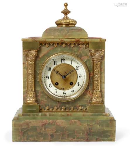 A late Victorian onyx mantel clock, the case of architectural design with a brass domed finial to