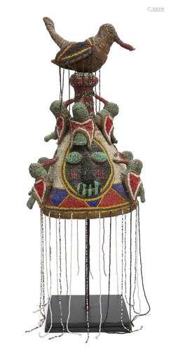 A Tribal headdress, Yoruba, Nigeria, of conical form with a bird finial at the top and bands of