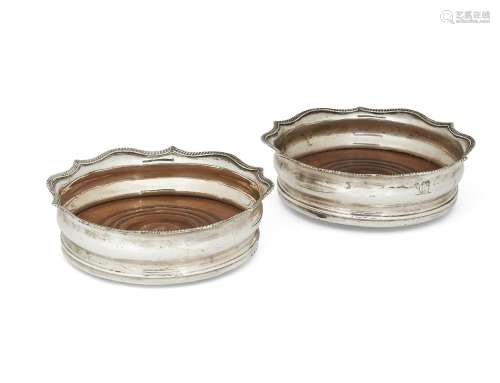 A pair of George III silver bottle coasters, London, c.1808, with turned wooden bases to plain sides