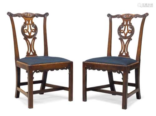 A pair of early George III and later mahogany side chairs, with foliate carved serpentine crest