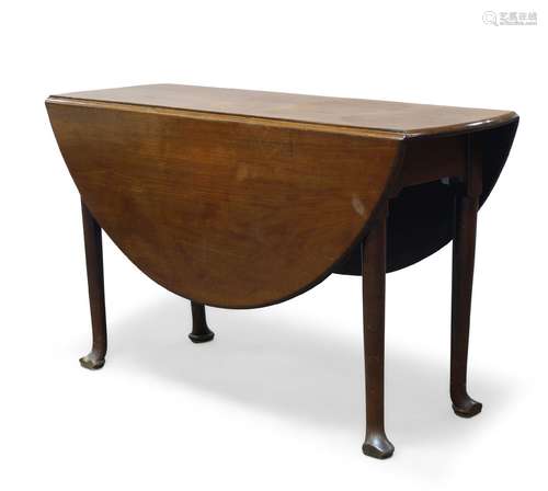 A George II mahogany oval drop leaf dining table, raised on cylindrical tapering legs to pad feet,