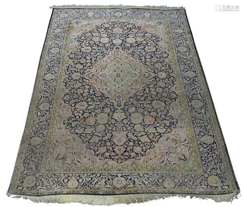 A Tabriz silk rug, mid/late 20th Century, with dusty pink medallion in deep blue floral decorated